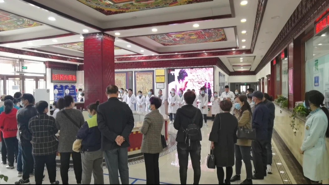医院大厅医护团队晨会，患者在旁等候