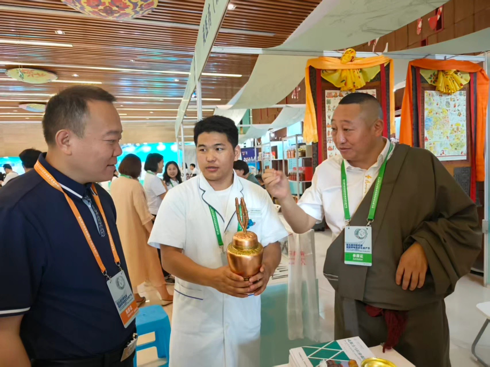 展会现场，青佩院长身着藏装向文旅局领导介绍名贵藏药佐塔