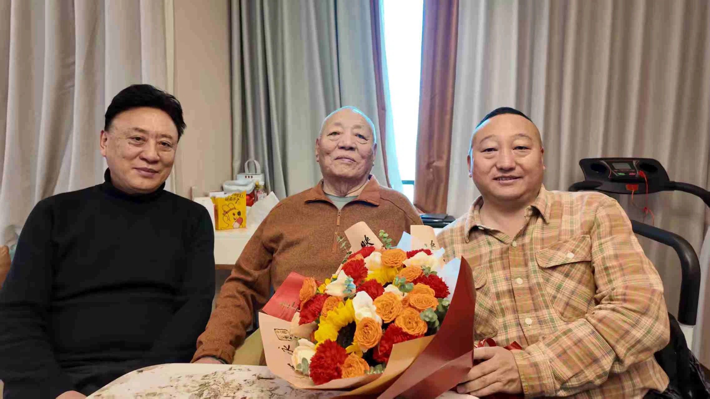 青佩院长与老活佛及友人三人合影，献花致意